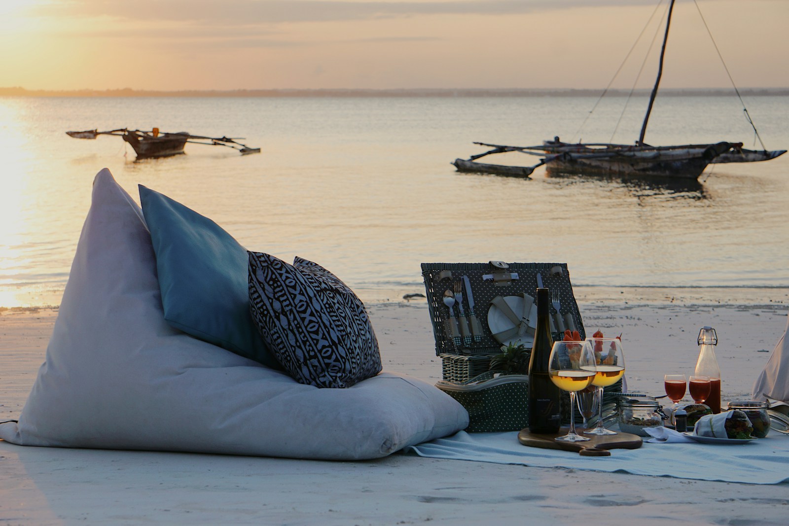 a couple of pillows sitting on top of a sandy beach